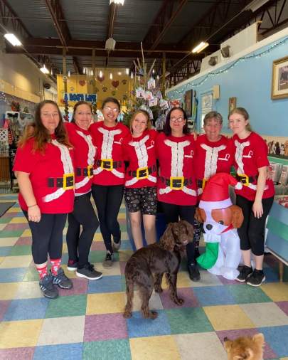 Our staff in a group picture dressed in Santa shirts